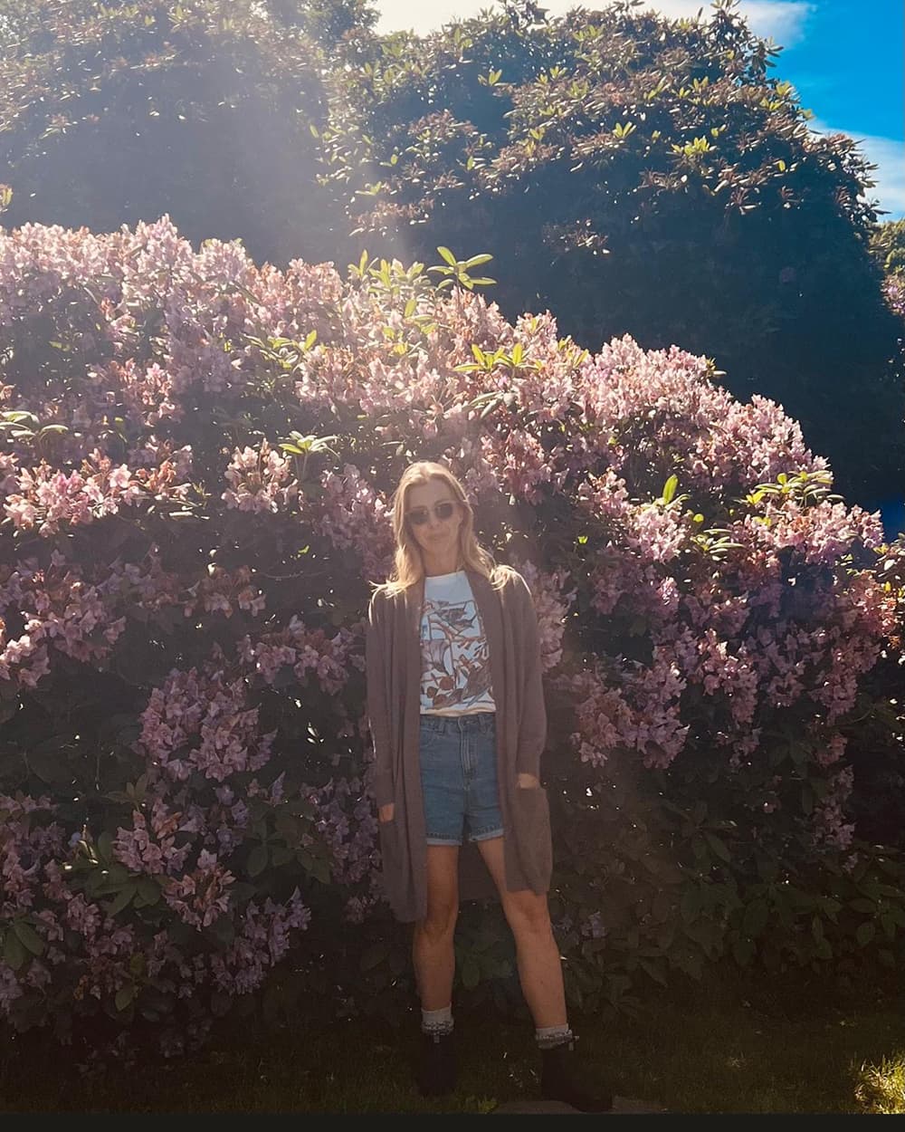 Sez standing in a flower bush